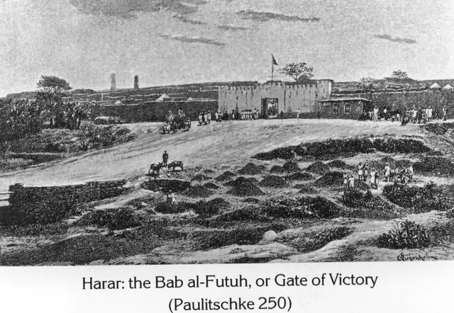 A view of the Bab al-Futuh gate in the walled city of Harar with figures and animals in the foreground.