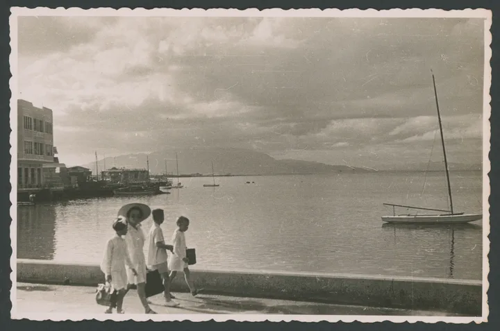 Una donna e tre bambini sul lungomare con porto di Massaua (Eritrea) sullo sfondo  
1 cartolina fotografica : gelatina a sviluppo 
Titolo ricavato da timbro sul verso
Timbri sul verso: Edizioni Foto Lusvardi Asmara Ripsoduzione [i.e. riproduzione] vietata; Massaua - (Eritrea)
Nota manoscritta sul verso: 37