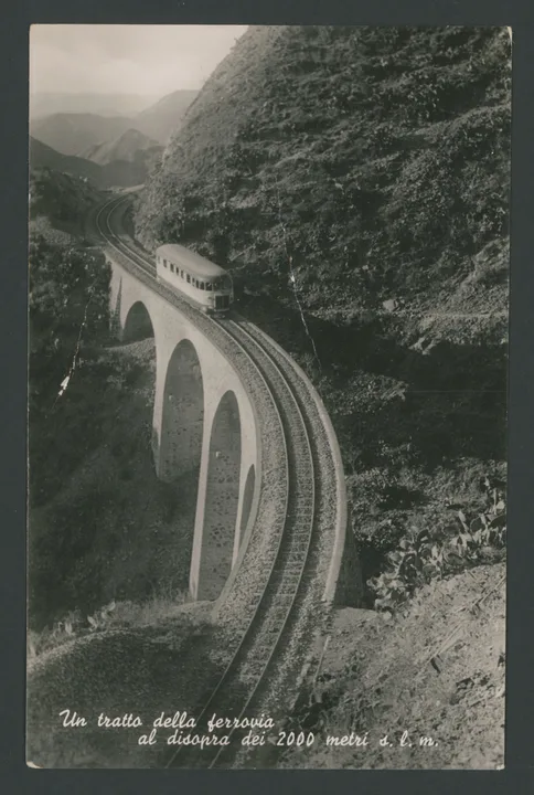 Littorina sul cavalcavia in Eritrea
1 cartolina fotografica : gelatina a sviluppo
Titolo ricavato da scritta a stampa sul recto: Un tratto della ferrovia al disopra dei 2000 metri s.l.m.
Testo manoscritto sul verso: Avv. Giuseppe Lanzieri - via Cino da Pistoia 7 - int. 11 - Roma; Pasqua 1954 - Vivissimi auguri unitamente alla signora Ines e al caro Franco, affettuosità. Paolo Maria [...] e Franca
Scritte stampate sul verso: Fotocelere Torino; 693-Ediz. Rag. F. Ferrero - Asmara Rip. Vietata; Vera Fotografia
Francobollo Etiope