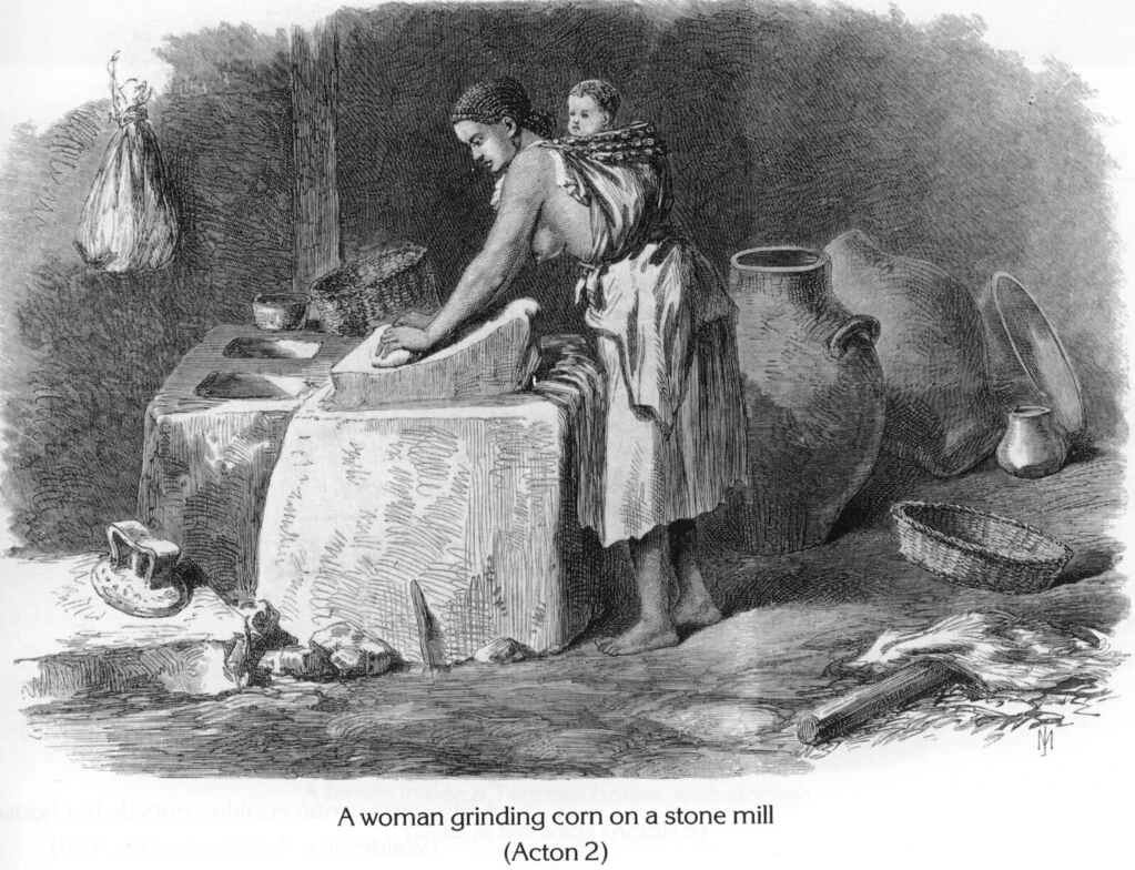 A woman grinding corn on a stone mill
