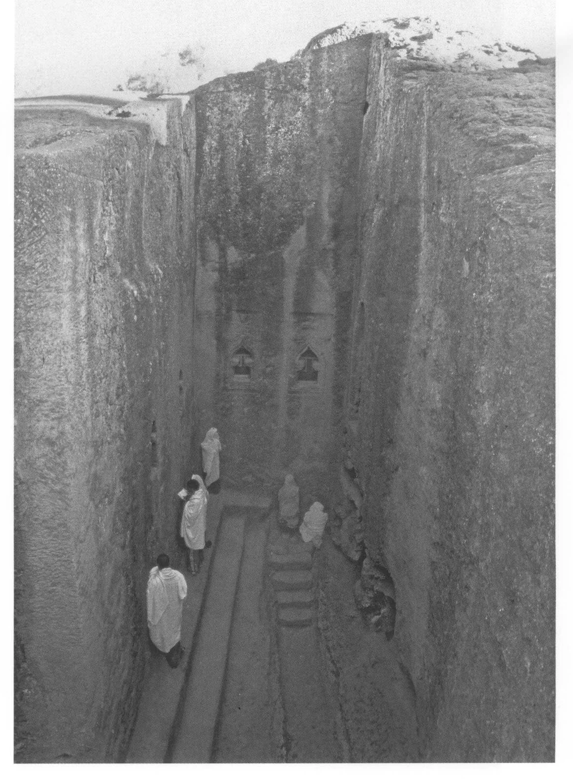 Lalibela, the trench on the east side of Beta Mika’el, looking north, 2006. The stepped plinth of Beta Mika’el is on the left. At the far end of the trench are two steleform windows with arabesque decoration; that on the left lights the Iyasus cell, that on the right the Sellassie chapel.