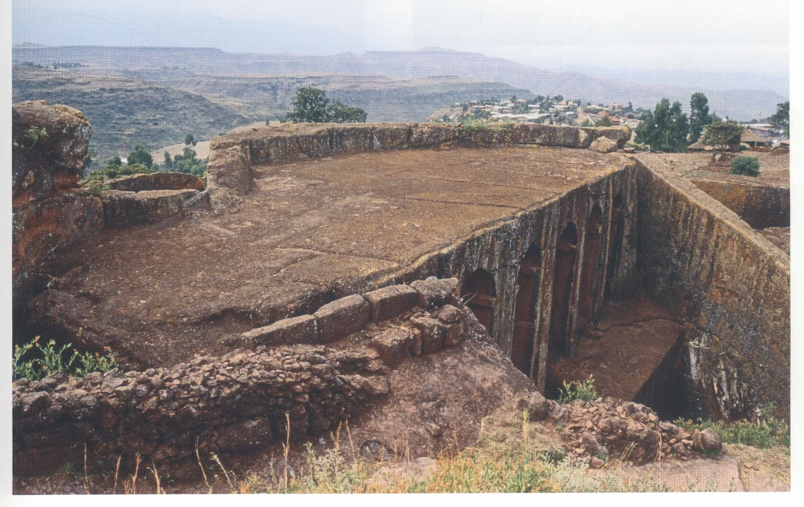 Beta Gabriel-Rafa’el, the roof of the twin churches, seen from the north-northeast, 2007. This photograph clearly shows how the roof has been carefully carved flat, leaving a rock parapet on the southeast side which separates the roof from the area enclosed by the walls of large stone blocks seen in fig. 196.