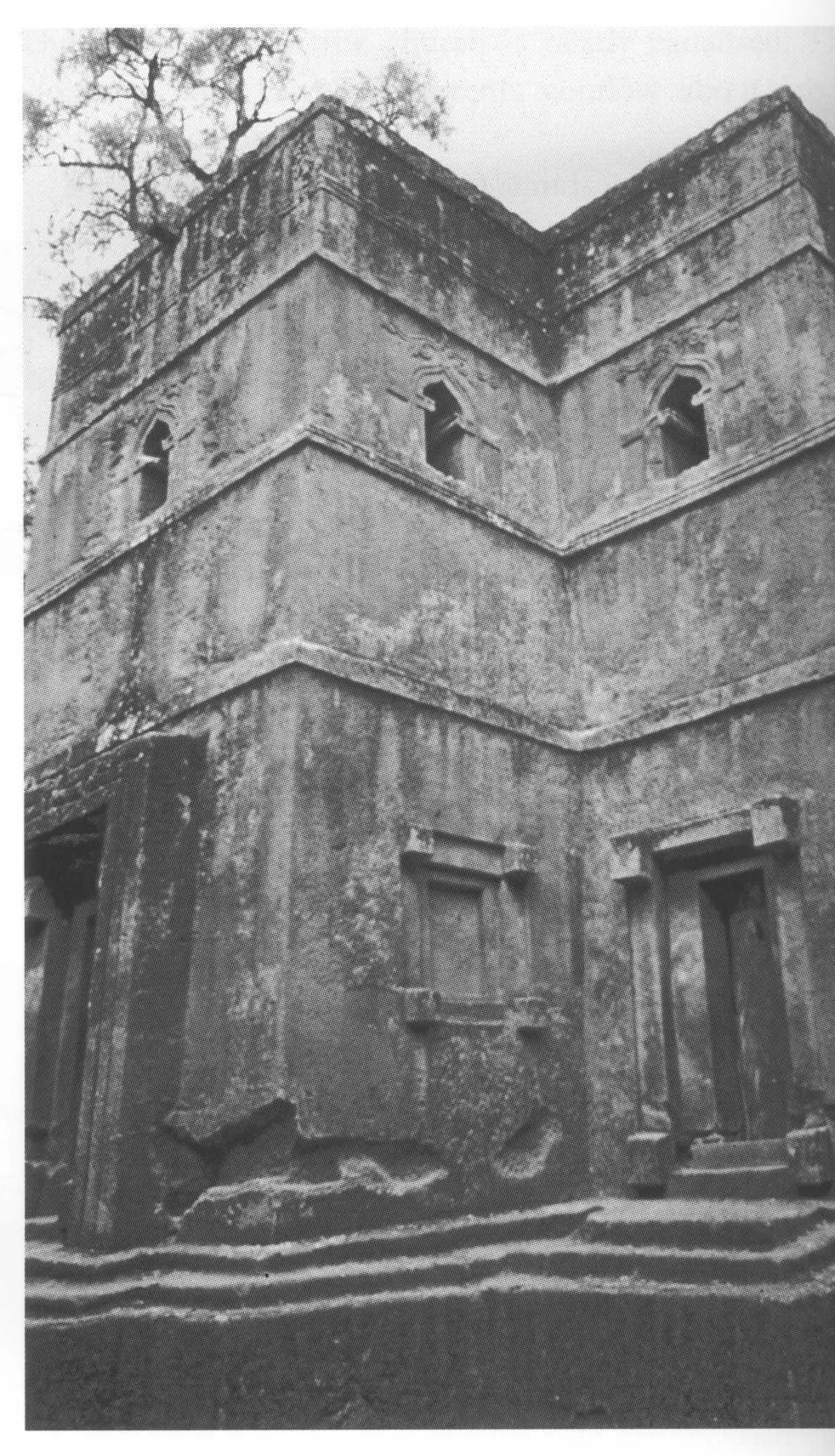 Beta Giyorgis, external view at the southwest corner, c. 1970. Part of the frame of the west door is visible on the left. Note the stepped plinth, one of the blind lower windows, and the south door.