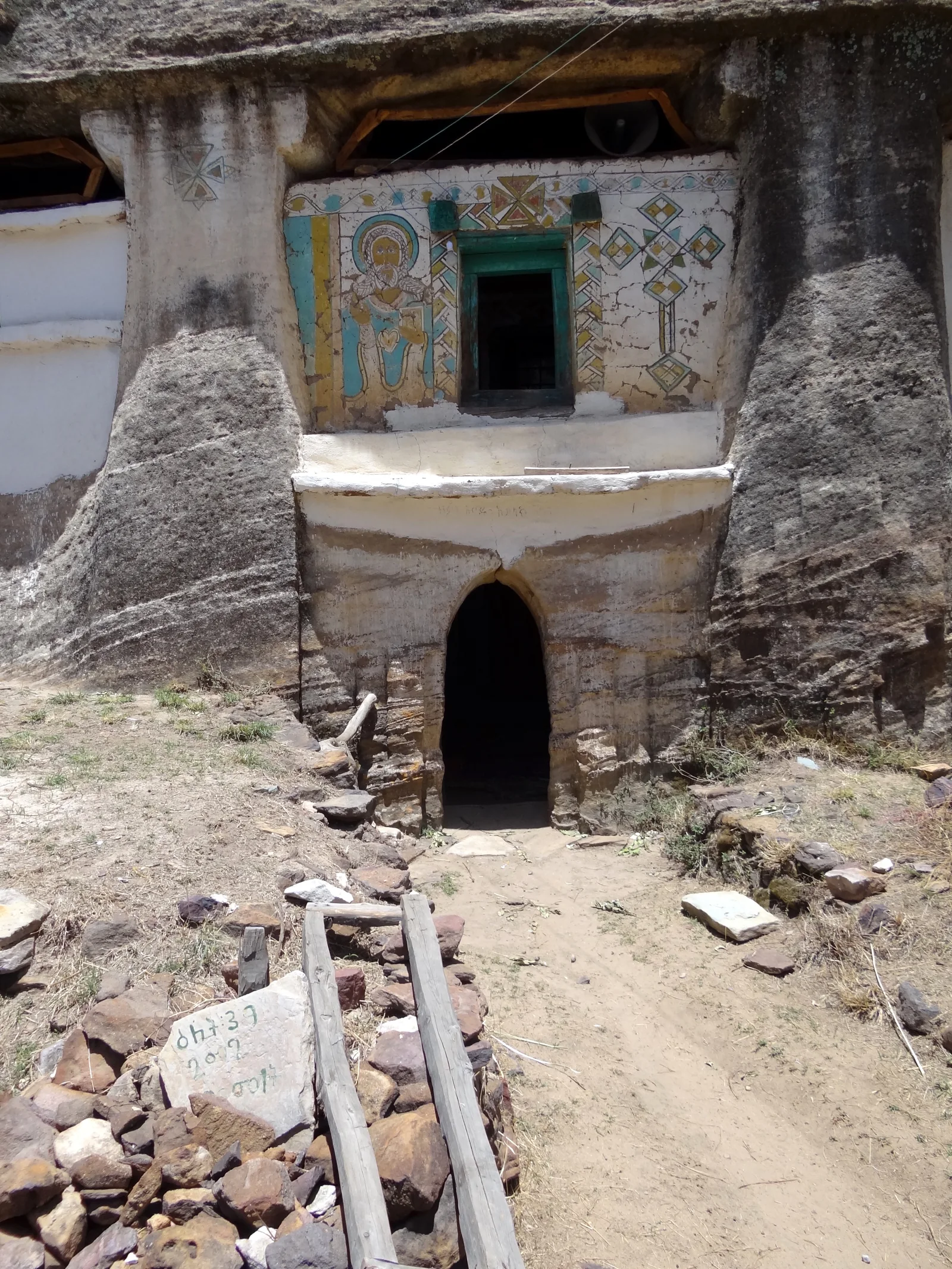 Madhane Alem Addi Qesho: frontal approach showing the lower rock-cut portal and decorated upper entrance block.